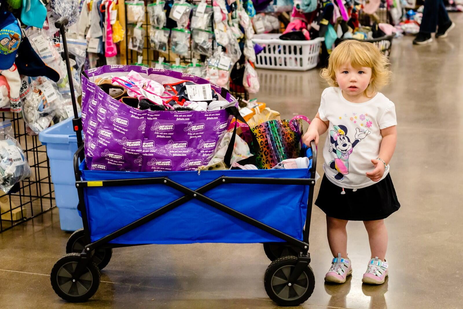 Grandmom, mom and baby in a carrier gather together and flash a smile as they shop for baby items.